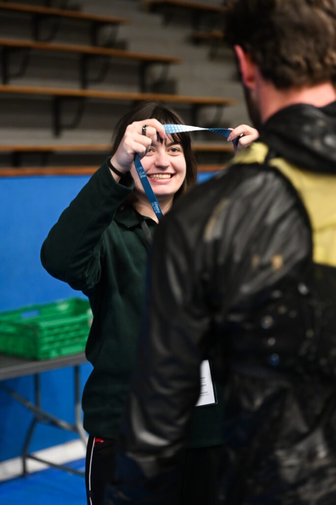 Bénévole remettant une médaille finisher
